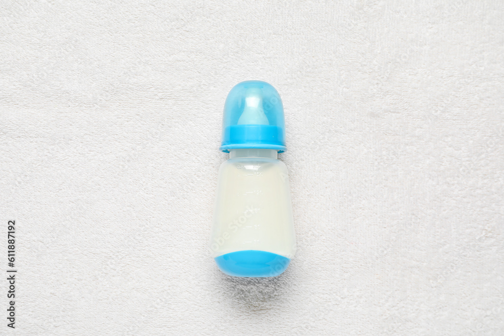 Bottle of milk for baby on white towel