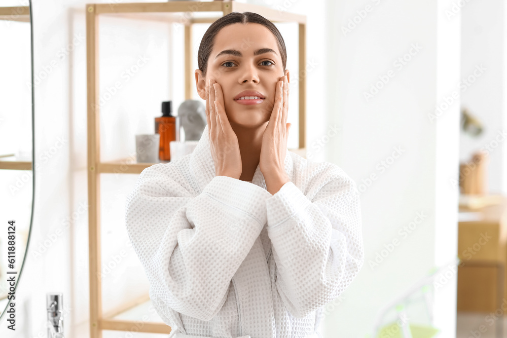 Young woman doing face building exercise in bathroom