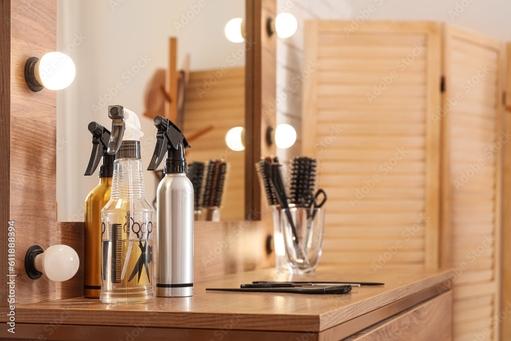 Different hair sprays on table in beauty salon