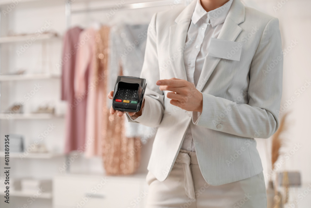 Female seller with payment terminal in boutique, closeup