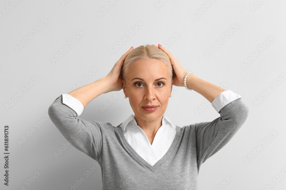 Mature blonde woman on light background