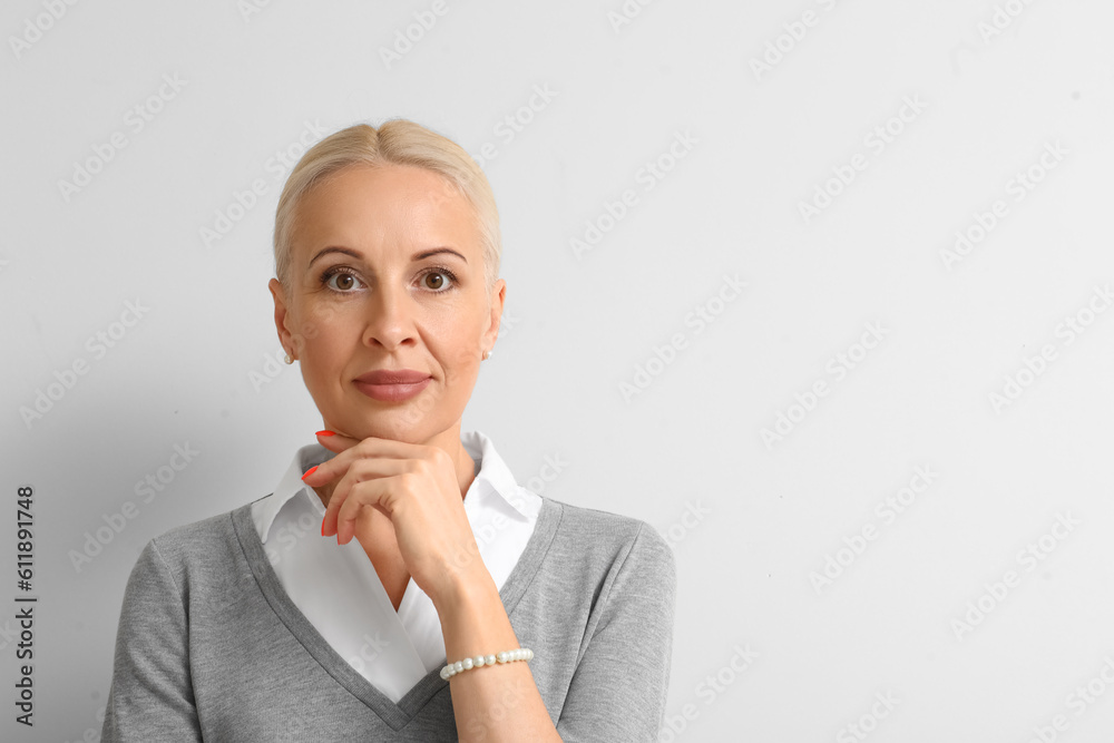 Mature blonde woman on light background, closeup