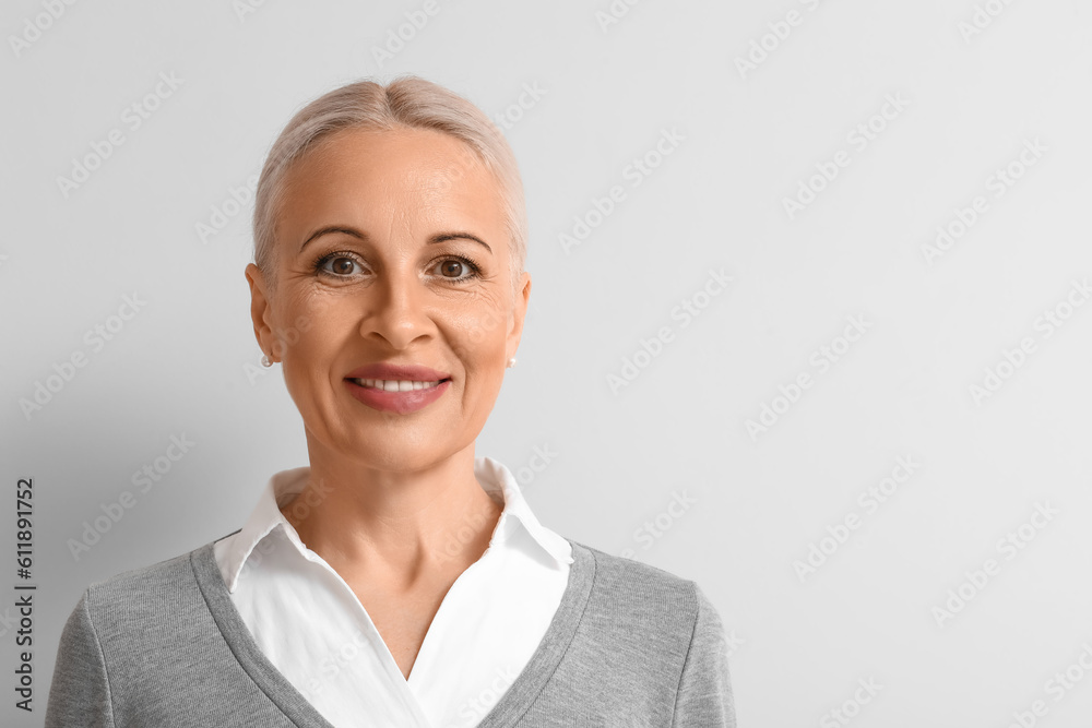 Mature blonde woman on light background, closeup