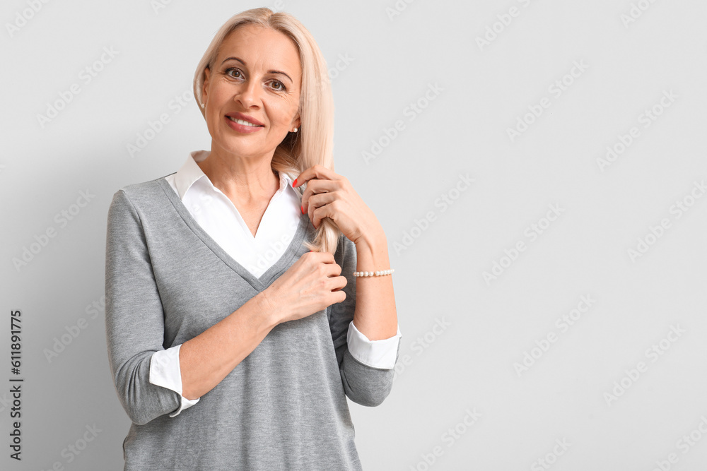 Mature blonde woman on light background