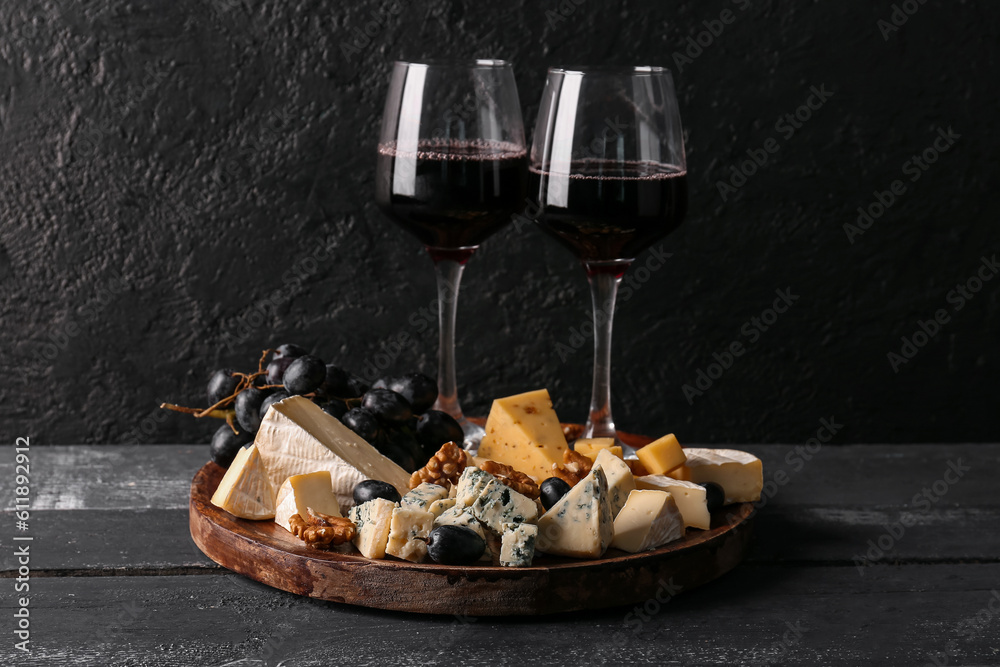 Pieces of tasty cheese and glasses with wine on table