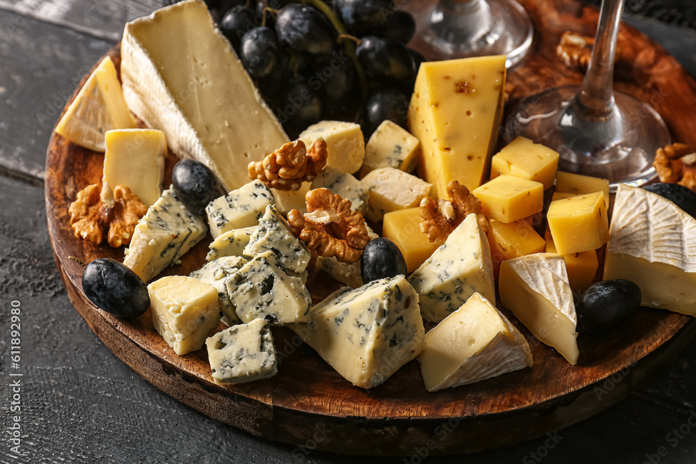 Plate with pieces of tasty cheese on table, closeup