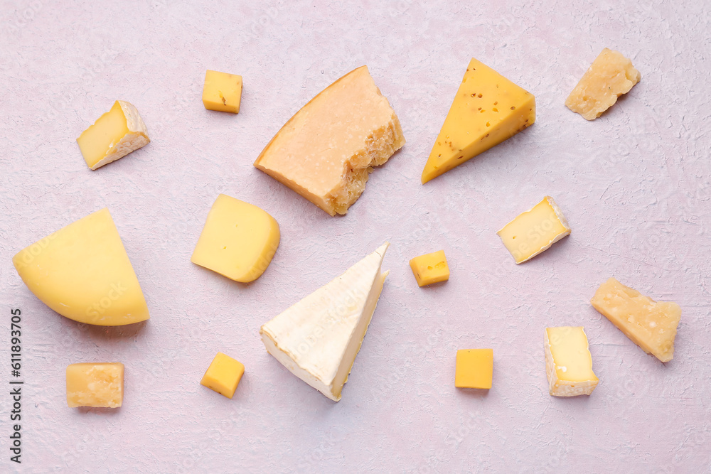 Pieces of tasty cheese on light background