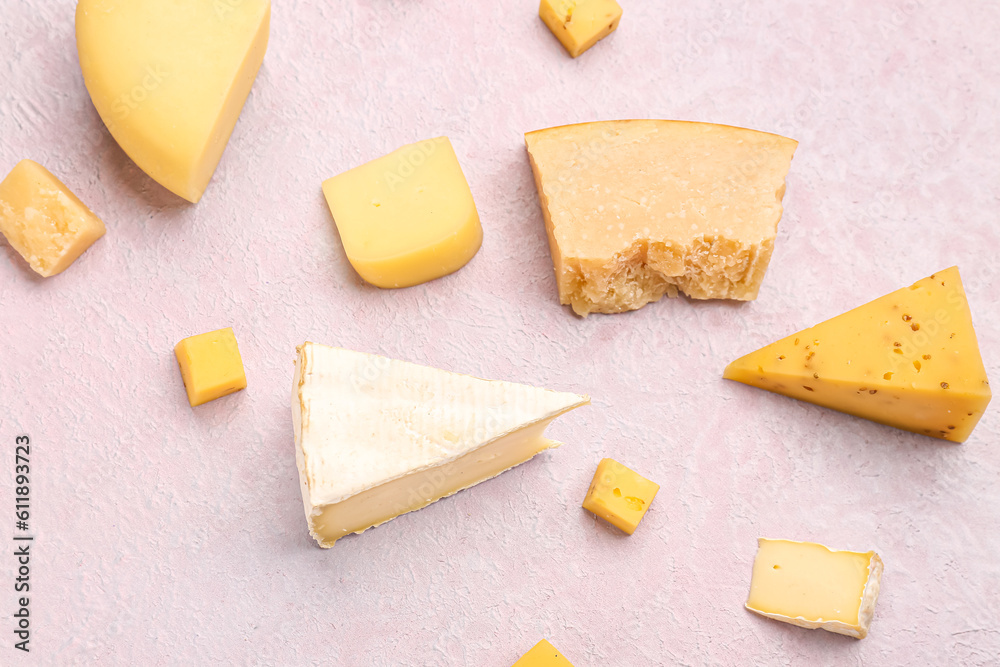 Pieces of tasty cheese on light background