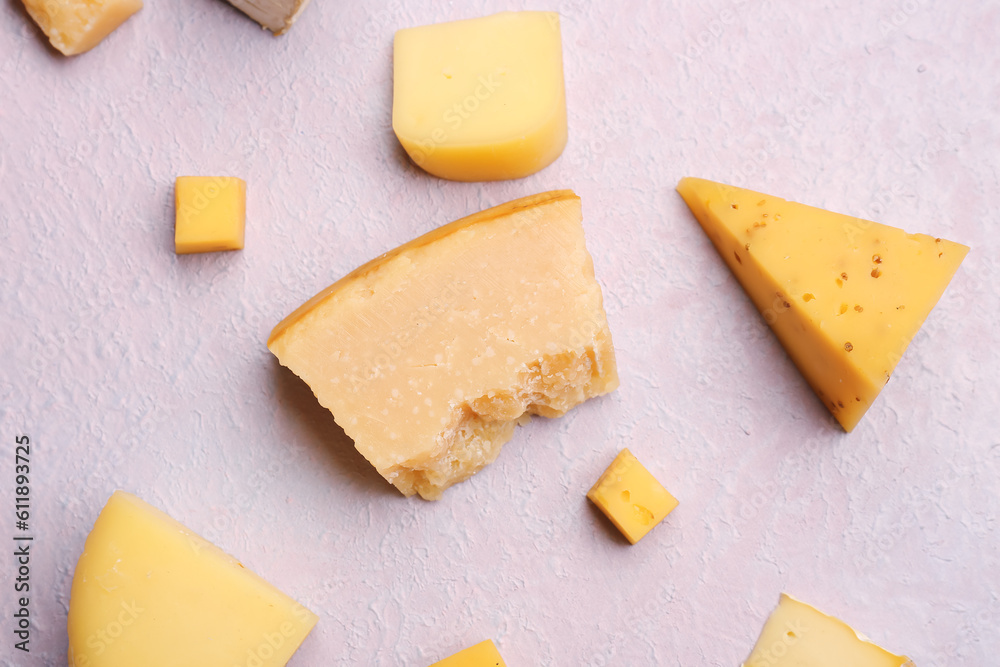 Pieces of tasty cheese on light background