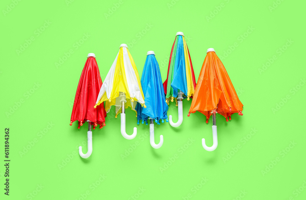 Many different umbrellas on green background