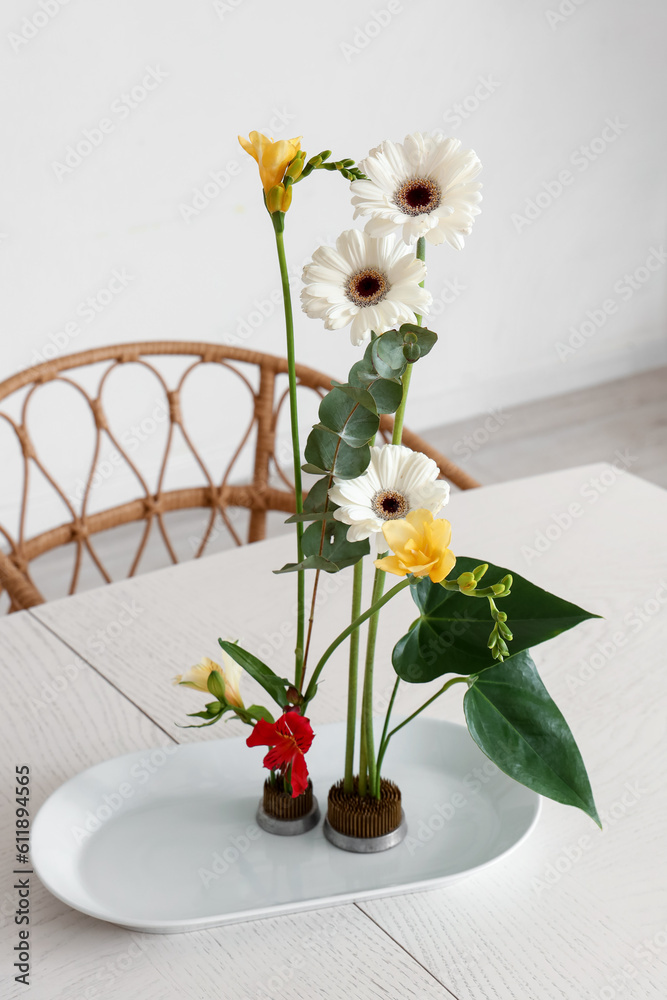 Beautiful ikebana on dining table in room