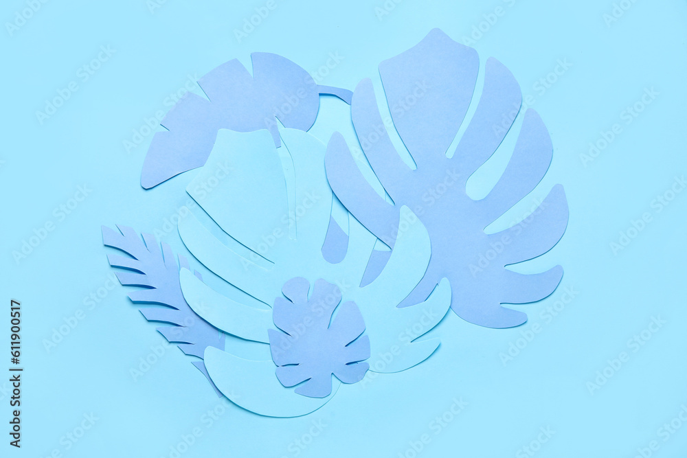 Different tropical leaves on blue background