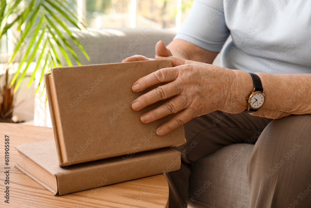 Senior woman with book at home, closeup