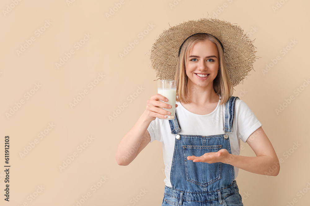 Female farmer with glass of milk on beige background