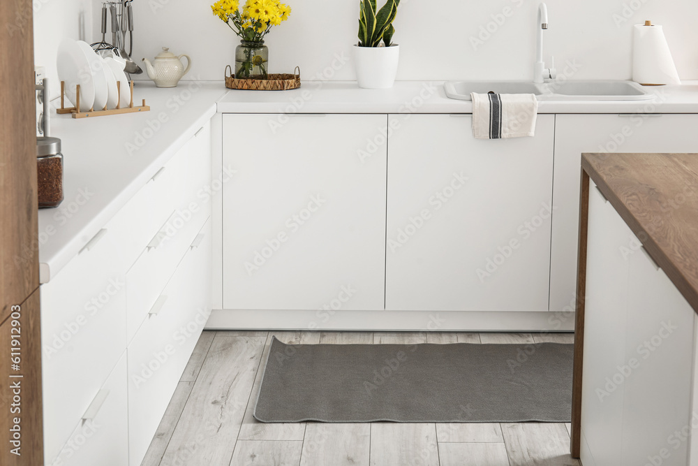 Stylish rug on floor in interior of light kitchen