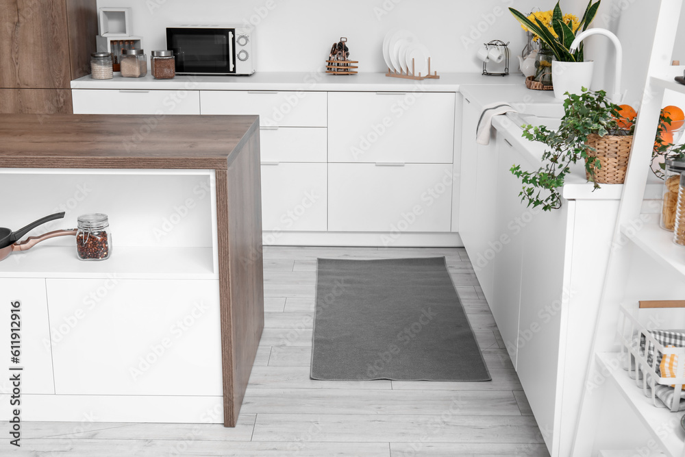 Stylish rug on floor in interior of light kitchen