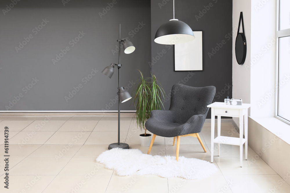 Interior of modern living room with black armchair and lamp