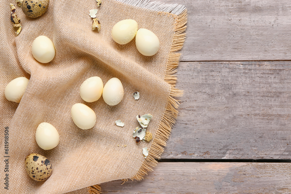 Boiled quail eggs with shells on grey wooden background