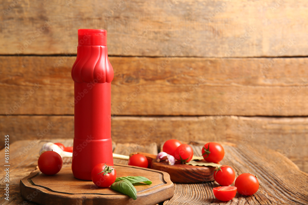 Board with bottle of ketchup and tomatoes on wooden table