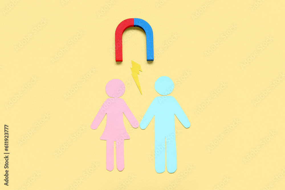 Couple made of paper with magnet and lightning on pale yellow background