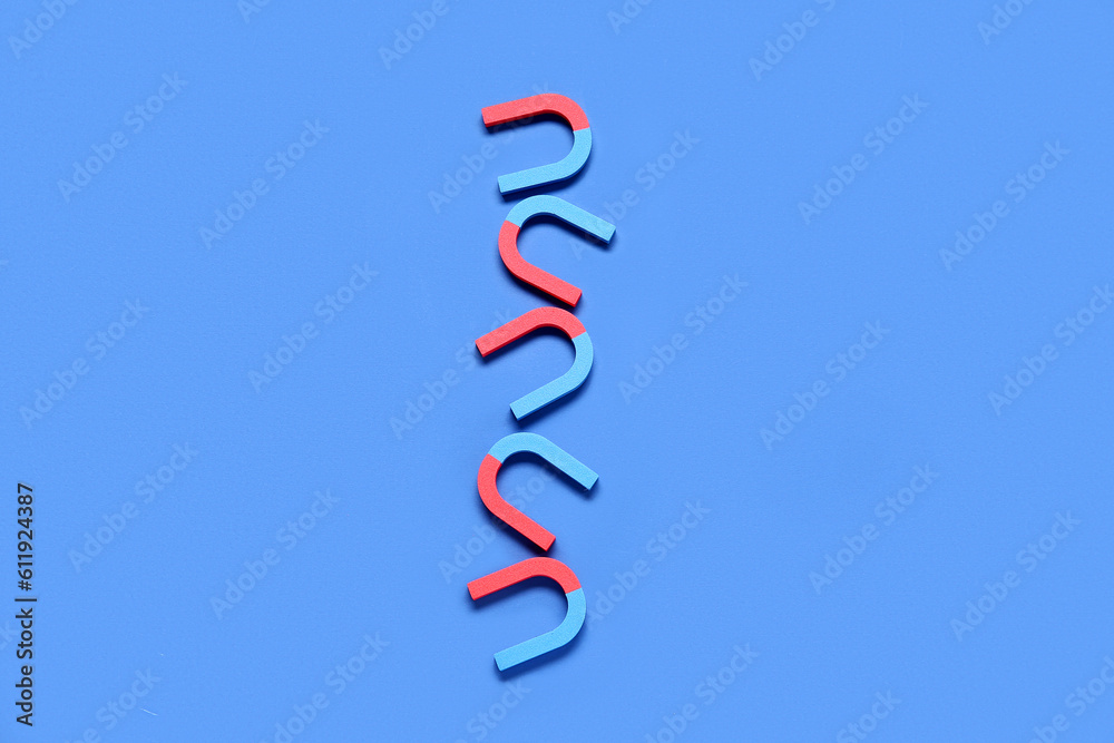 Horseshoe shaped magnets on blue background