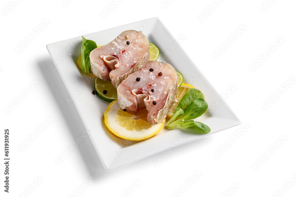 Plate with pieces of raw codfish on white background