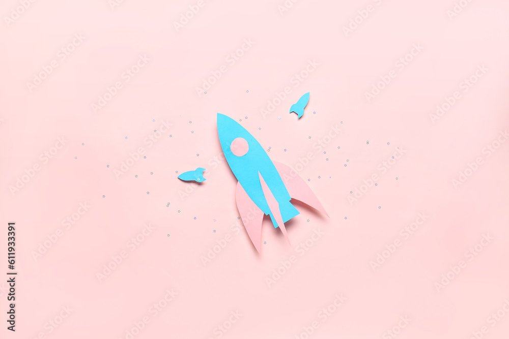 Blue paper rockets on pink background