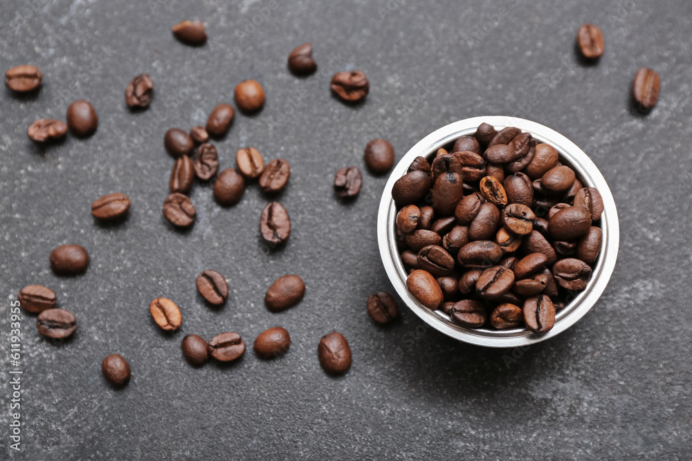 Bowl with coffee beans on dark background