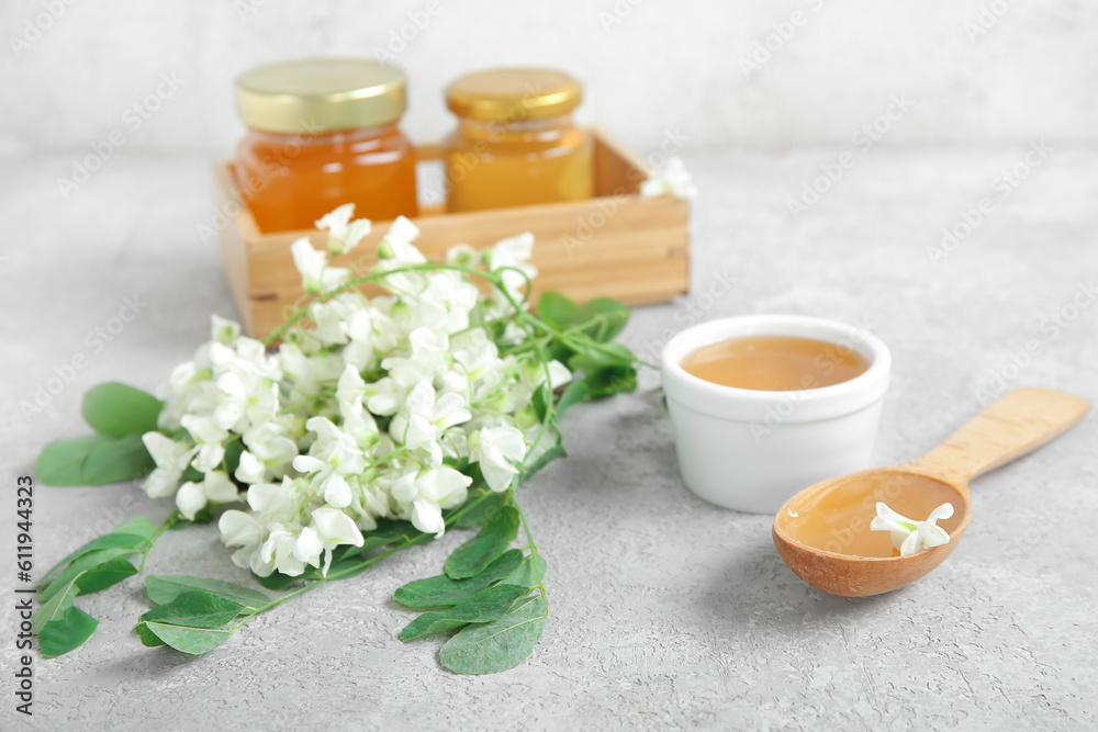 Composition with sweet honey and acacia flowers on light background, closeup