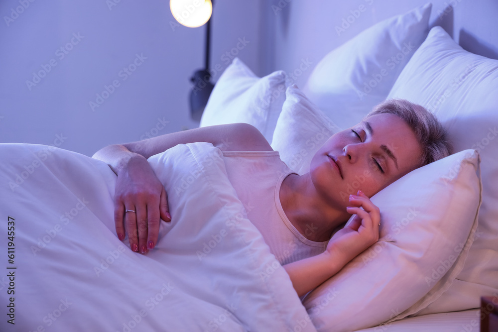 Young woman sleeping in bed at night