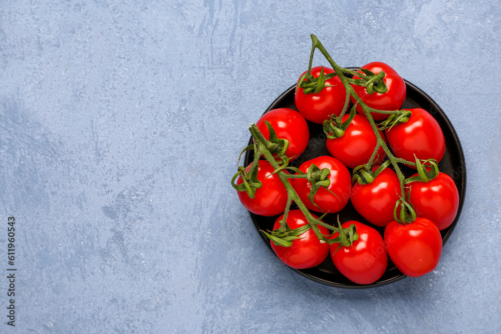 Tray with fresh cherry tomatoes on blue background