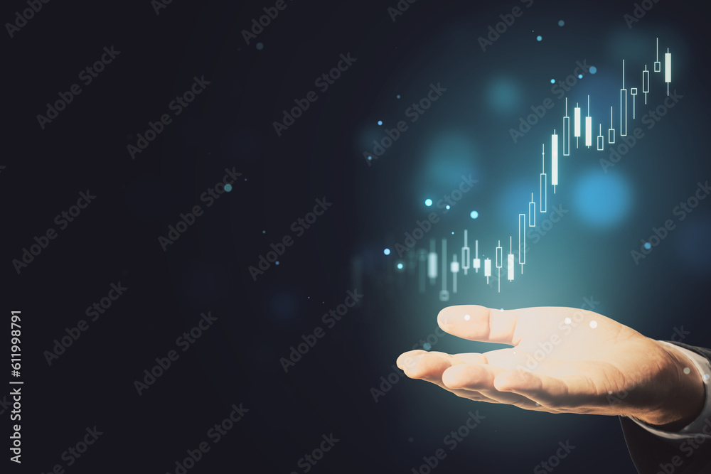 Close up of businessman hand holding glowing candlestick forex chart index on blurry dark bokeh back