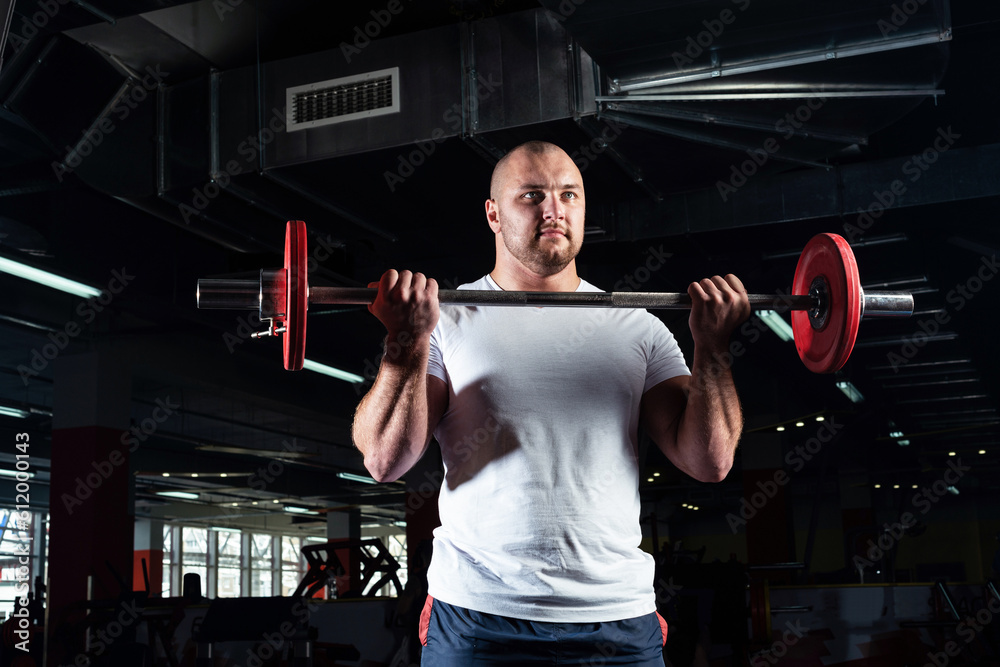 Male athlete lifts the barbell