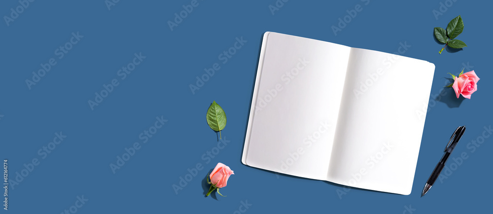 Open notebook or diary with a pen from above with rose buds- flat lay