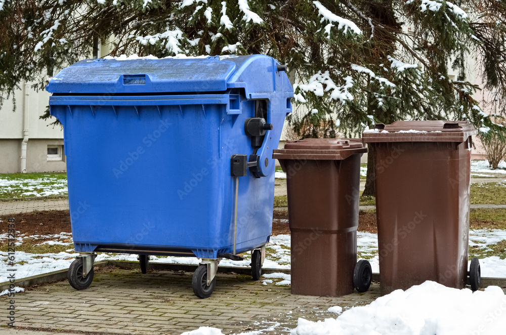 View of garbage containers in city on winter day