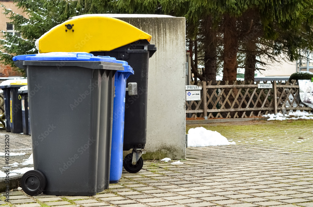 View of garbage containers in city on winter day