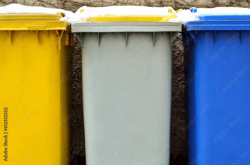 View of garbage containers in city on winter day