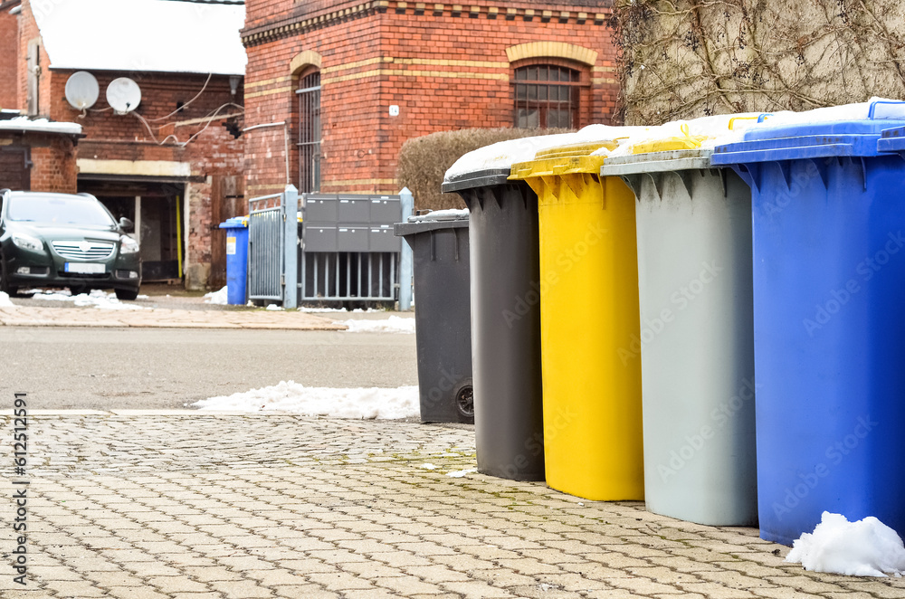 View of garbage containers in city on winter day