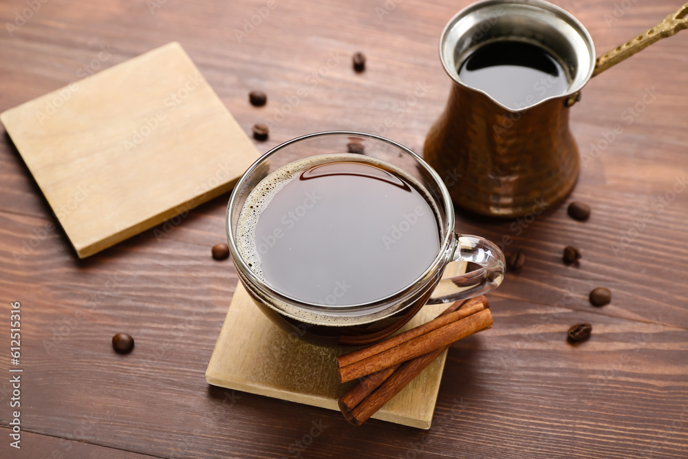 Drink coasters with cup of coffee, cinnamon and jezve on wooden table