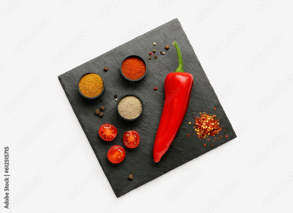 Slate board with fresh aromatic spices on light background