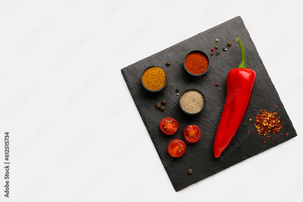 Slate board with fresh aromatic spices on light background