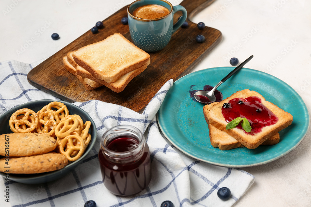 Tasty toasts with blueberry jam, cookies and cup of coffee on light background