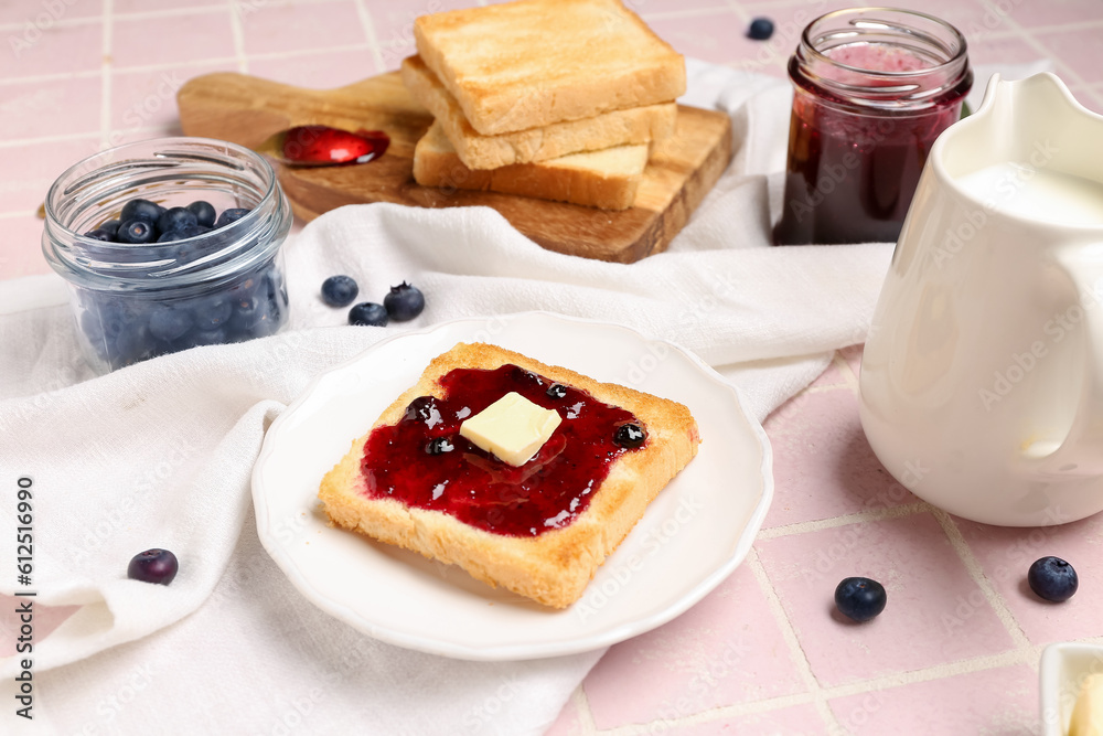 Plate of tasty toast with blueberry jam on pink tile background