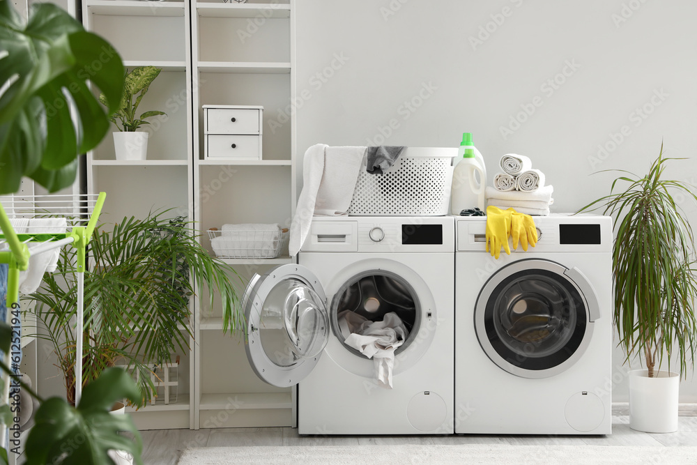 Interior of laundry room with washing machines and cleaning supplies