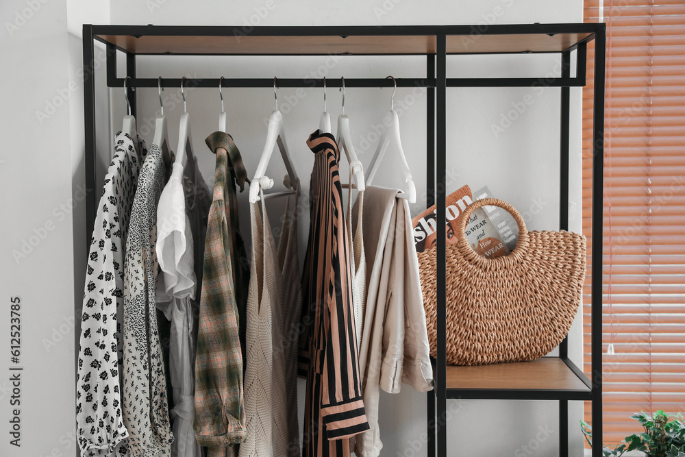 Shelving unit with clothes and bag in light bedroom