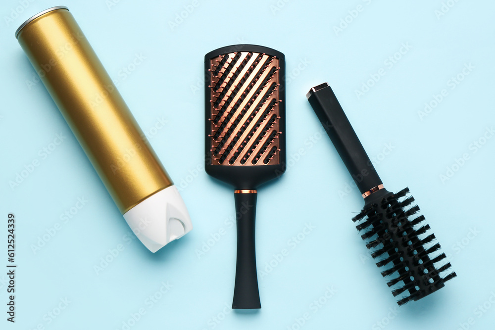 Hair brushes with spray on blue background