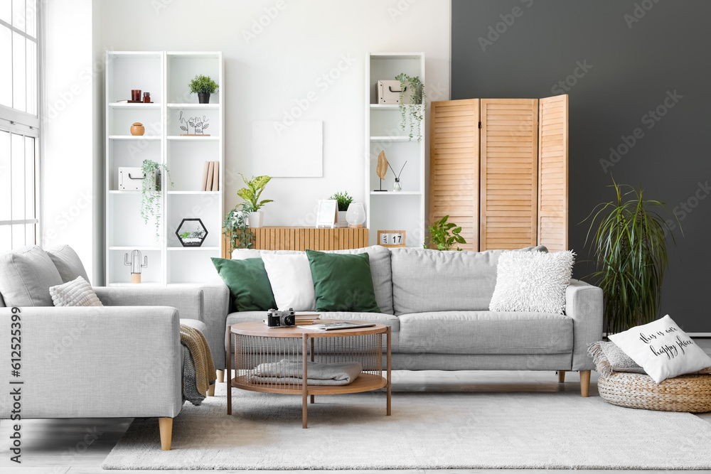 Interior of bright living room with cozy grey sofas and coffee table