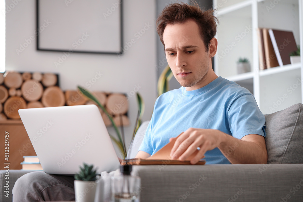 Male student with laptop doing lessons at home