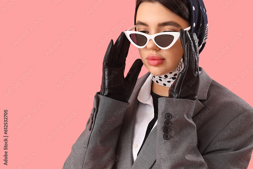 Stylish young woman in sunglasses and leather gloves on pink background, closeup