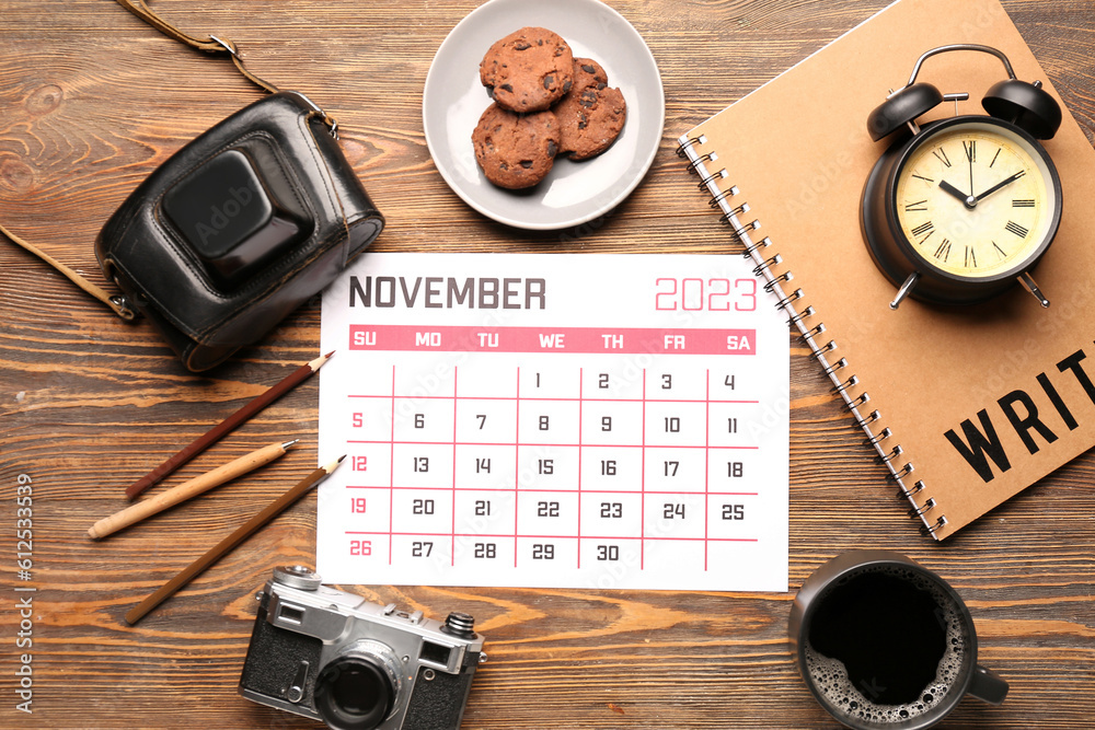 Composition with calendar, photo camera, cup of coffee and cookies on wooden background